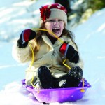 Young girl sledding in the snow